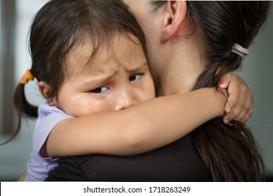 A sad child holding her mother for comfort and safety.  - Shutterstock ID 1718263249