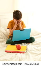 Sad Child With Laptop, Sitting On Bed Covering His Face With His Hands. Concept Of Cyberbullying, Learning Problems, Online Communication, Homework , Child Psychology, Mental Health, Digital, Kids