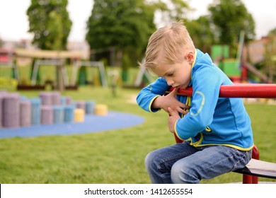 Sad Child On The Playground. Little Boy With Problems.