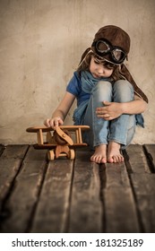 Sad Child Playing With Toy Wooden Airplane