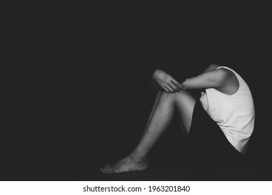 Sad Child Sitting On Floor In Dark Room, Black And White Image