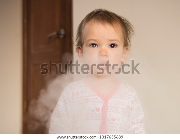 Sad child in the smoke. Danger of passive\
smoking concept.