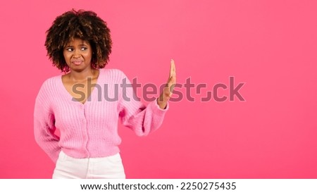 Sad confused millennial african american curly woman in casual show hand stop sign, isolated on pink background, studio, panorama. Emotions, disgust, rejection, fight with harassment, discrimination