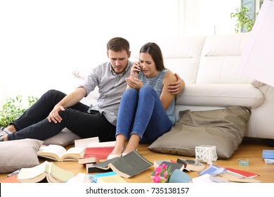 Sad Couple Calling To Police Sitting On The Floor Of The Messy Living Room After Home Robbery