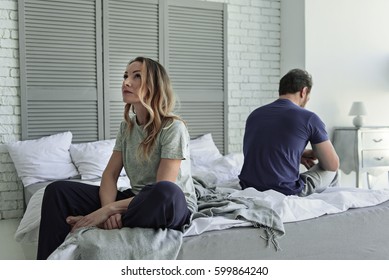 Sad couple sitting on bed