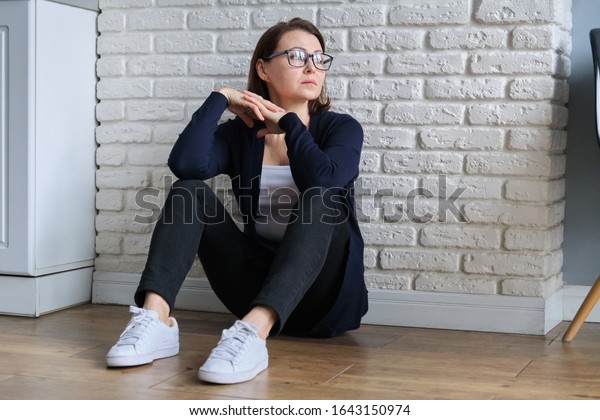 「床に座って悲しい落ち込んだ年の孤独な女性。鬱病、憂鬱、気圧の問題、成熟した女性の生活の精神的問題」の写真素材（今すぐ編集） 1643150974