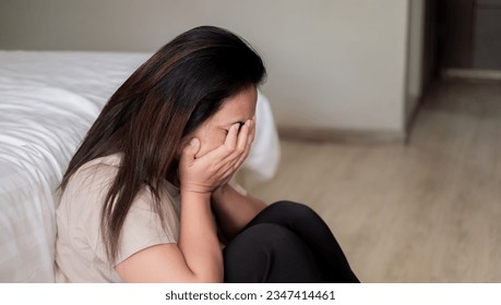 Sad depressed asia woman suffering on the white bed, she is sitting in bed and touching her forehead, sleep disorder and stress concept
