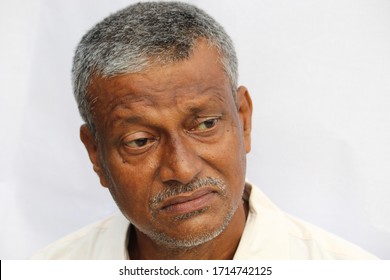 Sad And Depressed Looking Senior Indian Man Face Portrait On White Background.  Old Man Looking Side Way.