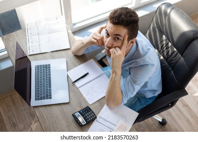 Sad Depressed Man Checking Bills, Anxiety About Debt Or Bankruptcy, Financial Problem, Bank Debt Or Lack Of Money, Unhappy Frustrated Young Male Sitting At Work Desk With Laptop And Calculator
