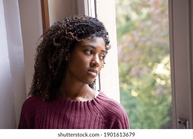 Sad depressed mixed race african american looking out window