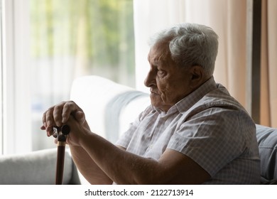 Sad depressed older 80s man holding gimp stick knob, using walking cane, having disability, mobility problems, joints, bones disease. Lonely older patient feeling apathy, loneliness, pain
