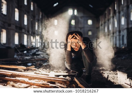 Sad depressed person in abandoned destroyed building crying.Emotional portrait.Screaming woman in excruciating pain.Problem,stress and disappointment.Disaster in life,lost and grief.Madness and trauma
