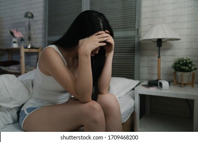 Sad Depressed Woman Suffering From Insomnia Cover Face In Dark Bedroom. Unhappy Asian Japanese Lady Sitting In Bed And Touching Her Forehead With Hands At Home. Sleep Disorder And Stress Concept.