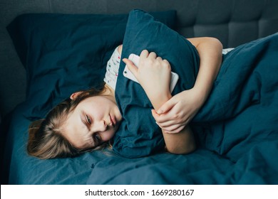 Sad depressed  young woman hugging pillow lying in bed alone, upset frustrated caucasian lady feeling lonely anxious suffer from insomnia trying to sleep thinking of problem in bedroom - Powered by Shutterstock