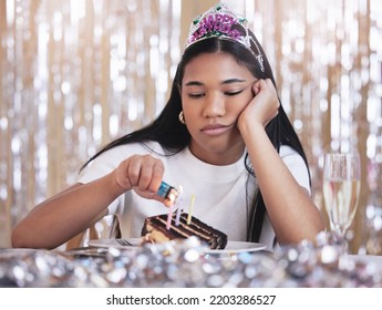 Sad, Depression And Angry Woman At Birthday Celebration While Lighting Candle On Cake. Lonely, Depressed And Frustrated Female Sitting At A Party, Fail And Table With Snack, Decoration And Tiara