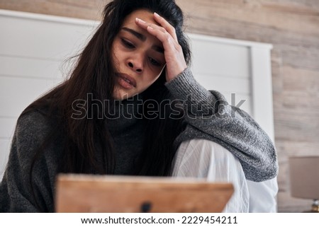 Sad, depression and woman with frame in home looking at photo, feeling grief for death or loss. Mental health, anxiety or lonely female thinking of problems or frustrated after breakup alone in house