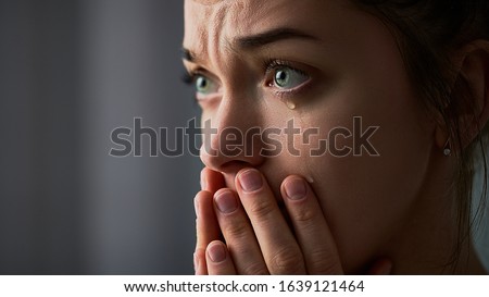 Sad desperate grieving crying woman with folded hands and tears eyes during trouble, life difficulties, depression and emotional problems