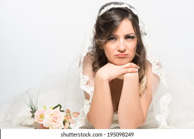 Sad and disappointed bride lying on the floor with rose flower