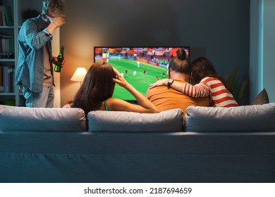 Sad disappointed group of friends watching a football match on TV, their team is losing the match - Powered by Shutterstock