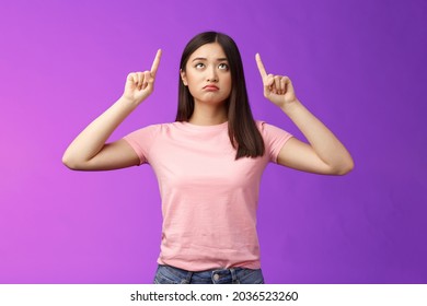 Sad Disappointed Sulking Asian Girl With Short Dark Haircut, Look Pointing Up Upset, Feel Jealous, Regret, Missing Good Opportunity, Staring Unhappy Top Advertisement, Stand Purple Background