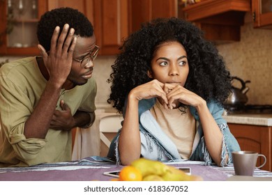 Sad Disappointed Woman Can't Forgive Her Husband For Infidelity Who Is Sitting Next To Her Having Apologetic Guilty Look, Saying It Was A Mistake. African American Couple Facing Relationships Problems