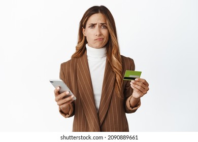 Sad And Disappointed Woman Holding Credit Card And Smartphone, Bad User Experience With Mobile App, Problem With Card Register Online, White Background