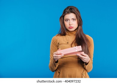 Sad Disappointed Young Woman Holding Opened Present Box Over Blue Background