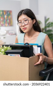 Sad disillusioned disappointed woman in glasses with regret leaves her job in the company, she was fired by disability, illness, wheelchair, injustice of employer, boss