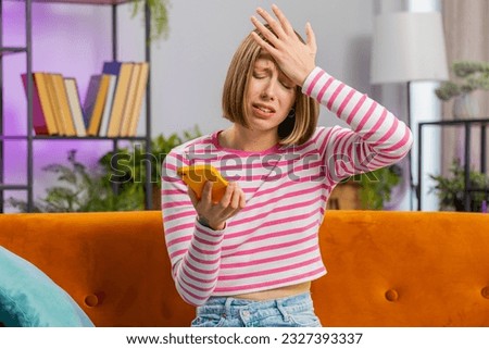 Sad displeased woman use smartphone typing browsing, loses becoming surprised sudden lottery results bad news, fortune loss fail deadline, virus. Portrait of brunette girl at home living room on couch