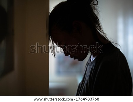 Sad distraught woman in her room at home.