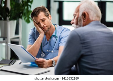 Sad Doctor Feeling Disappointed While Reading Medical Documents Of His Senior Patient During Consultations At The Clinic. 