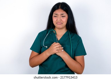 Sad Doctor hispanic woman wearing surgeon uniform over white background desperate and depressed with tears on her eyes suffering pain and depression  in sadness facial expression and emotion concept