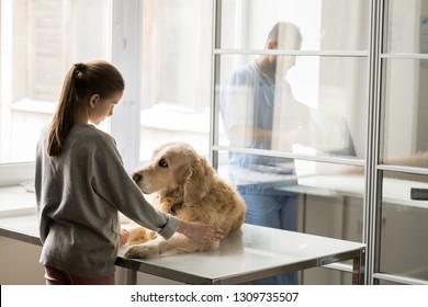 Sad dog on medical table and little girl in casualwear looking at one another before operation in veterinary hospital - Powered by Shutterstock