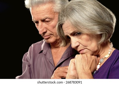 Sad Elderly Couple On A Black Background