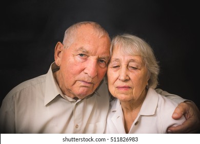 Sad Elderly Couple On A Black Background. Coronavirus CoVid-19, Illness And Senior People Concept