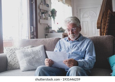 Sad elderly man reading health insurance deal closing looking and reading the medical results. Sick mature senior feeling bad with bank agreement with specialist. Checking outcomes at home.