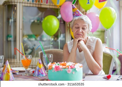 Sad Elderly Woman At A Birthday Party