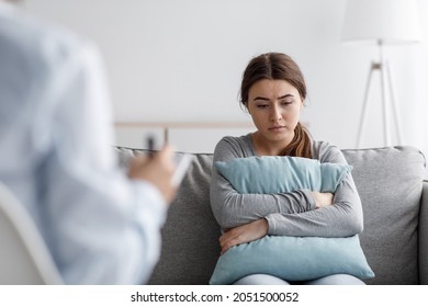Sad european young woman suffering from depression and consults with psychologist in clinic, empty space. Mental therapy, survive personal crisis, individual counselling, problems and treatment - Shutterstock ID 2051500052