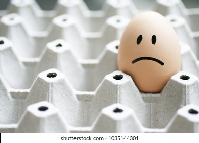 Sad Face On Eggs In Egg Box Background. Bad Day Feeling Concept