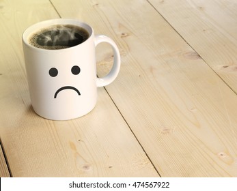 Sad face on mug or coffee cup on wood table