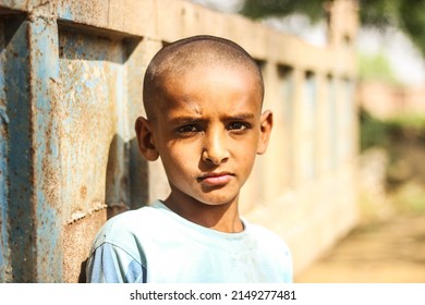 Sad Face Portrait Of A Young Child Or Young Boy From Rural Part Of India. Poor Village Bald Boy. Gurgaon, Haryana, India - April-24-2022