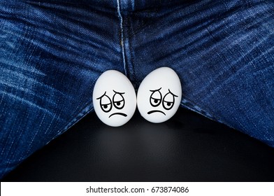 sad faces on the testicles of the guy. White eggs - a symbol of man's balls with the comic cartoon faces