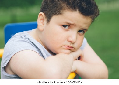 sad fat boy sitting on the sports simulator