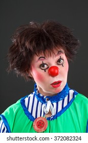 Sad Female Clown On A Gray Background
