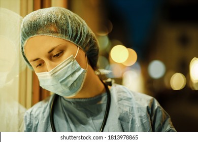 Sad Female Doctor Or Nurse Feeling Down Near Hospital At Night