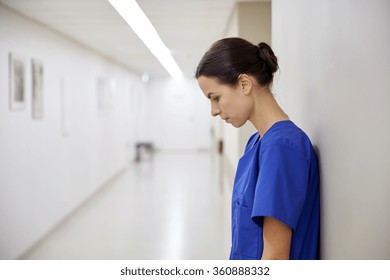 Sad Female Nurse At Hospital Corridor