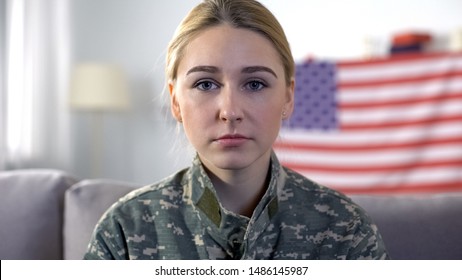 Sad Female Soldier In Camouflage Uniform Looking At Camera, USA Flag Background