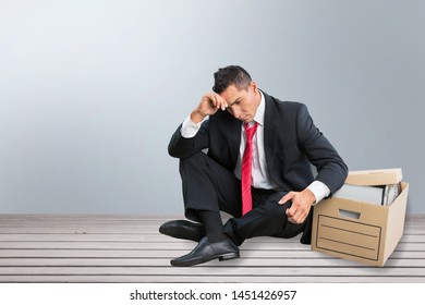 Sad Fired Businessman Sitting Outside Meeting Room After Being Dismissed