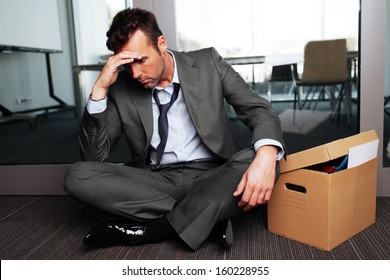 Sad Fired Businessman Sitting Outside Meeting Room After Being Dismissed