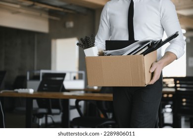 Sad Fired. Let Go Office Worker Packs His Belongings into Cardboard Box and Leaves Office. Workforce Reduction, Downsizing, Reorganization, Restructuring, Outsourcing. Mass Unemployment Market Crisis. - Powered by Shutterstock